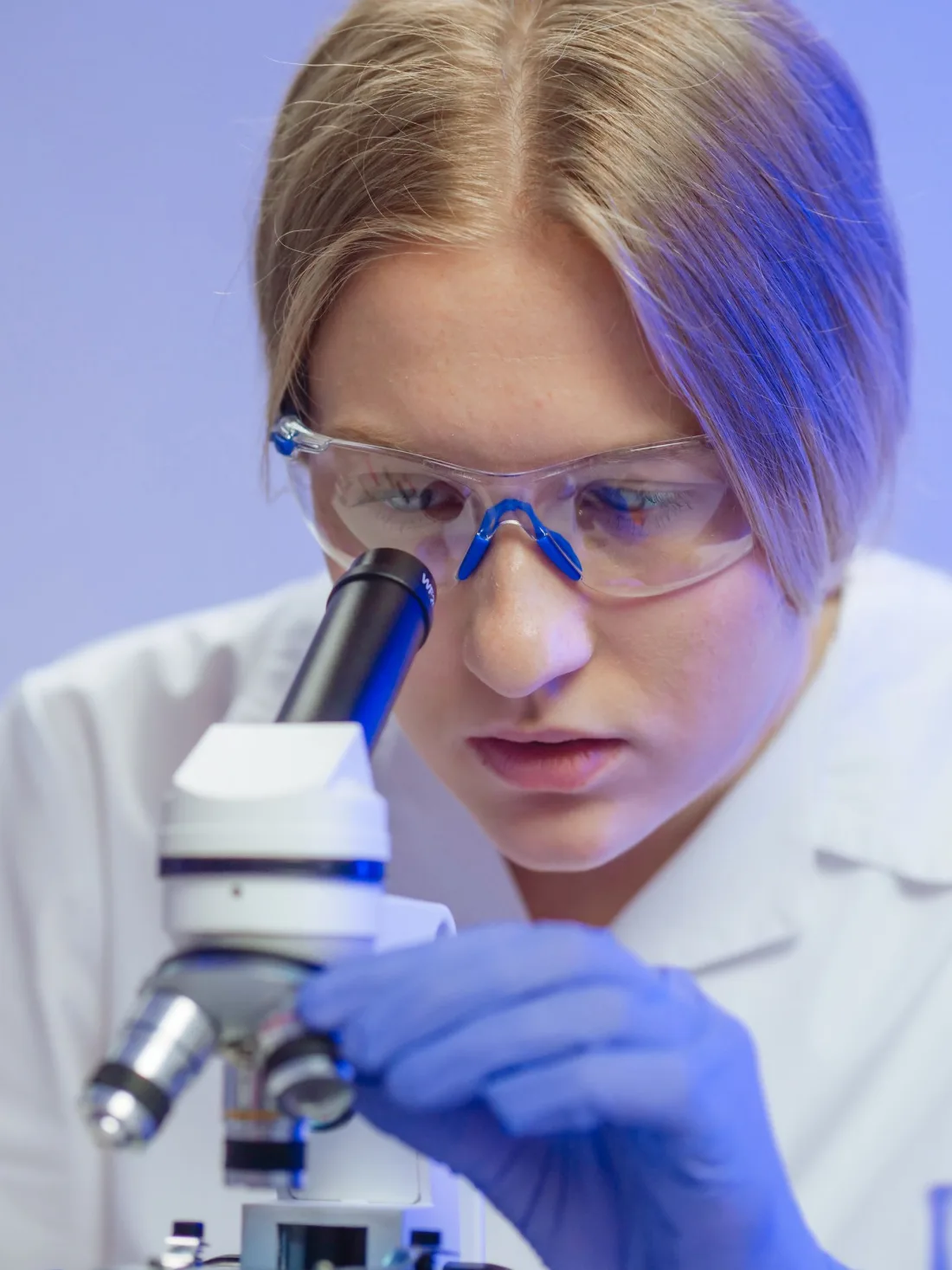 Student examining a sample under a microscope